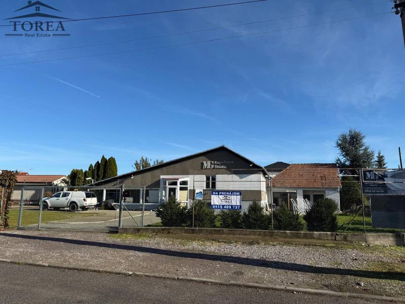 Commercial premises in Dolné Chleby with parking in front of the building and signage for rent.