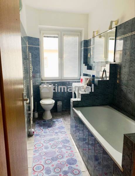Bathroom in a 2-room apartment with a bathtub, blue tiles, and a toilet.