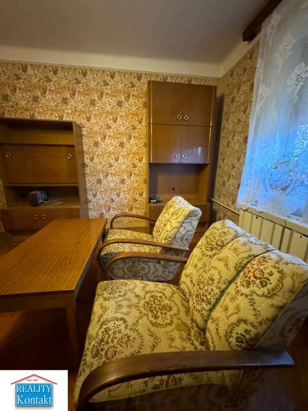 Interior of a family house with antique furniture and decorative wallpaper on the wall.