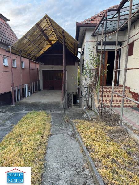 A family house in the center of Veľké Lovce with a shelter, stairs, and a garden path.