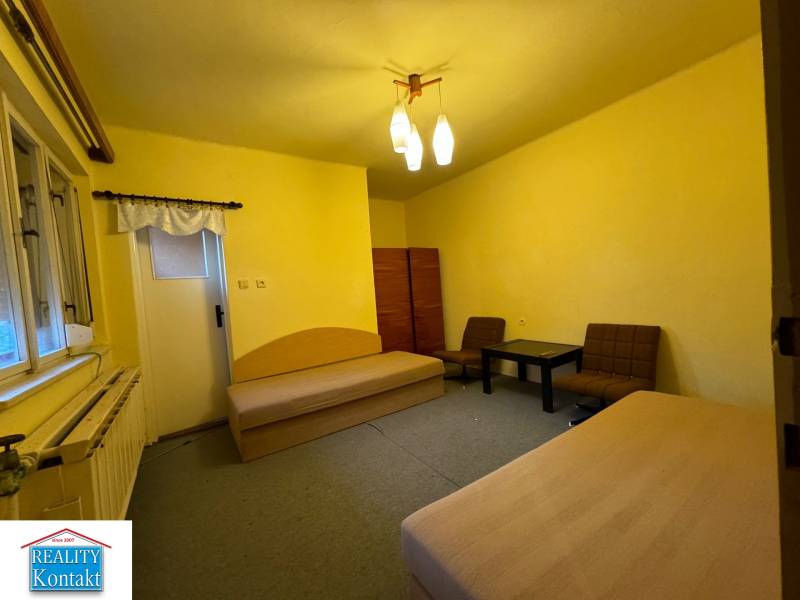 Living room in a family house with sofas, a table, and yellow walls.