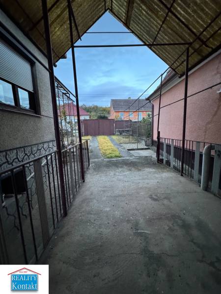 A family house in the center of Veľké Lovce with a view of the paved courtyard and garden.