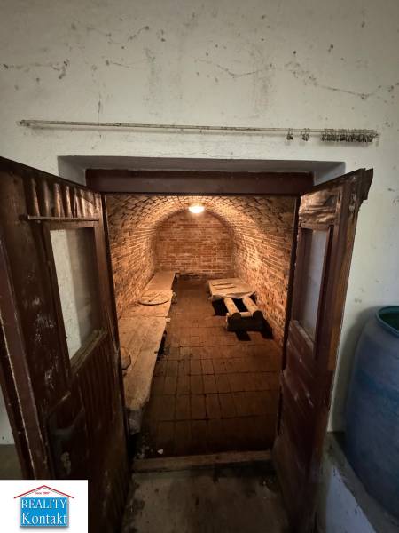 The family house has a brick cellar with simple lighting and wooden doors.