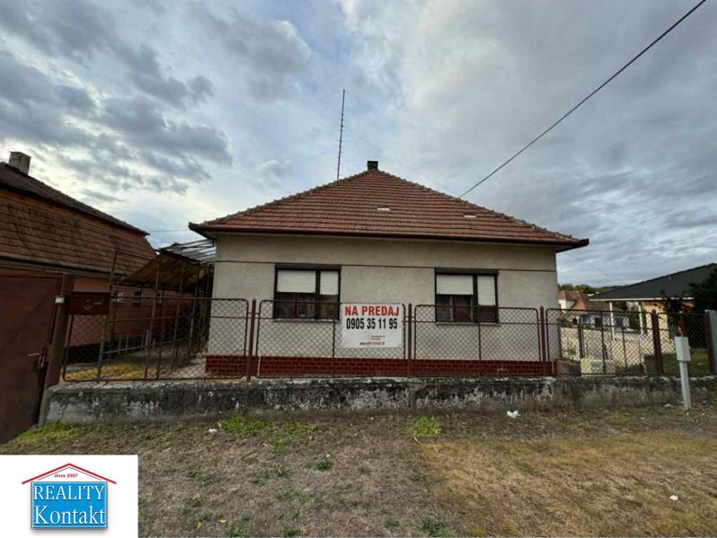 A family house in the center of Veľké Lovce with a brick roof and fencing.