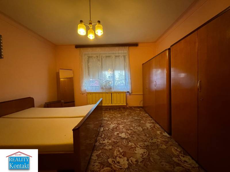 Bedroom in a family house with a wardrobe, bed, and carpet.