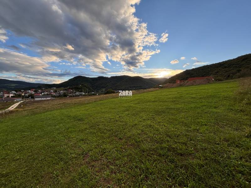 Sunset over the green lands in Margecany, surrounded by hills and the sky.