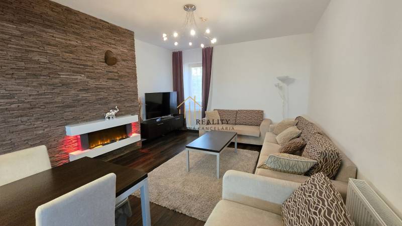 Living room in a 3-room apartment with a fireplace, wood-patterned flooring, and comfortable seating.