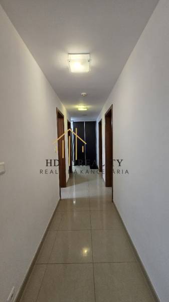 A hallway in a 3-room apartment with light walls and tiles.
