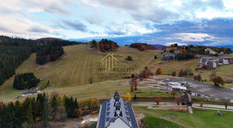 Ski slopes and forests in Donovaly with mountain buildings in the background.
