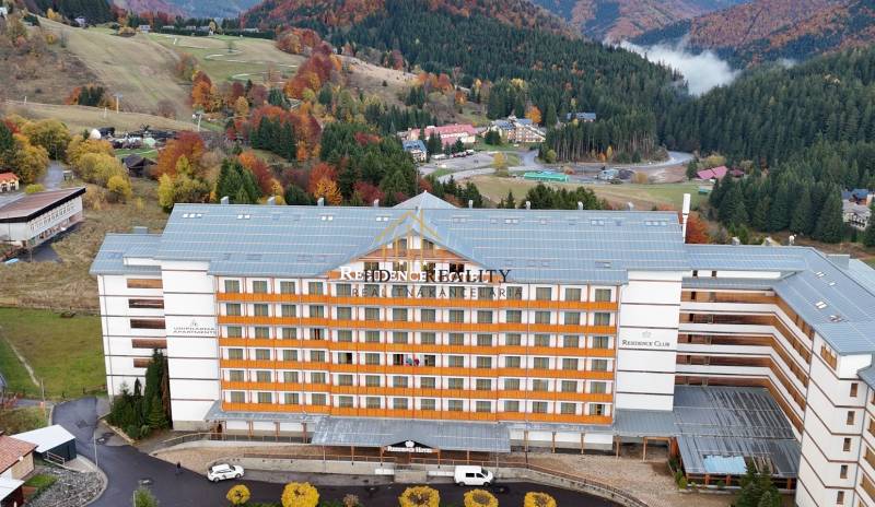 An aerial view of a hotel surrounded by autumn landscape in Donovaly.