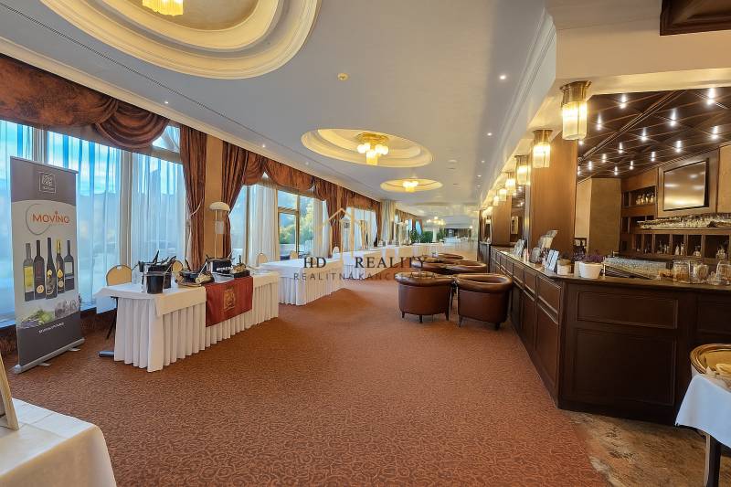 Luxurious room with a bar, tables, and leather armchairs, floor with wooden decor.