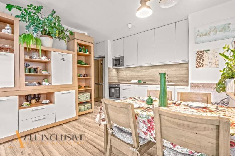 A kitchen in a 3-room apartment with a wooden decor floor and floral decorations.