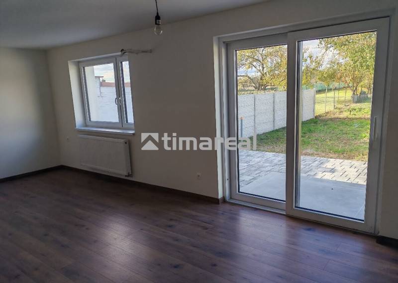 Interior of a 3-room apartment with large windows and a floor with a wooden decor.