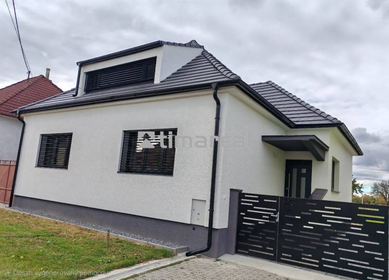 A family house in Jaslovské Bohunice with a white facade and a black roof.