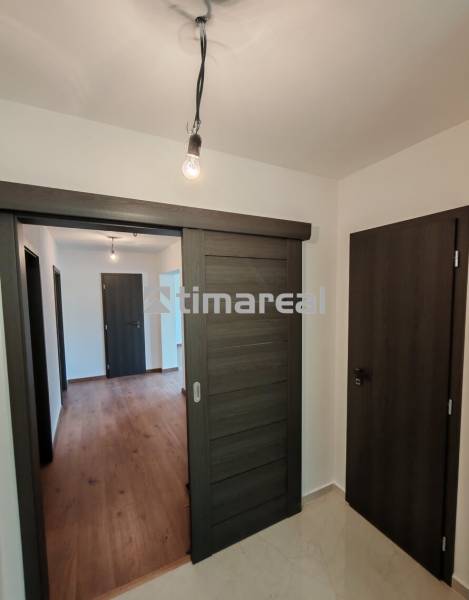 Interior of a 3-room apartment with a wooden decor floor and sliding doors.