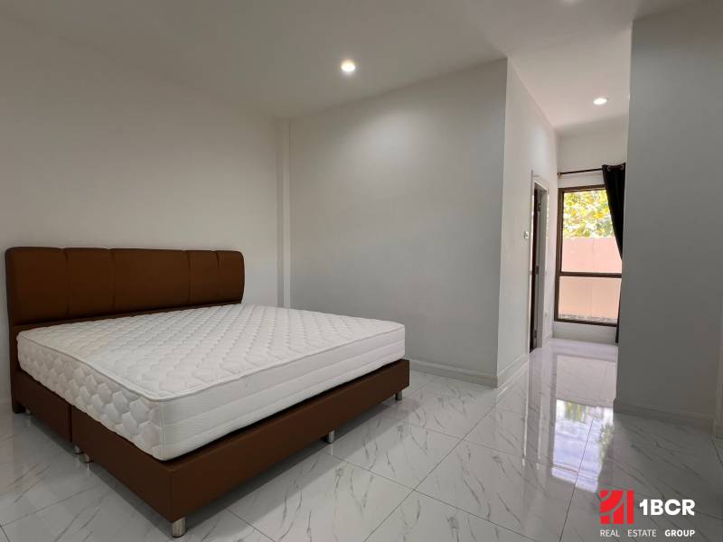 Interior of a villa with a bed and shiny ceramic tiles.