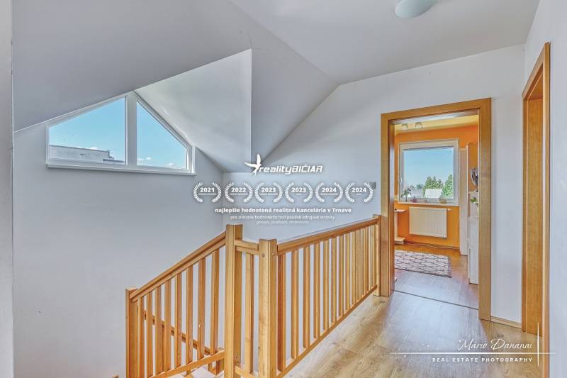A family house with a wooden decor floor, staircase, and a bright hallway.