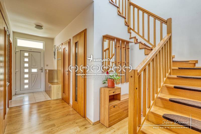 A staircase with a wooden railing in a family house, a floor with a wooden decor, storage spaces.