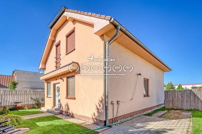 A family house in Cífer on Cífer Street with a lawn and a fence in the yard.