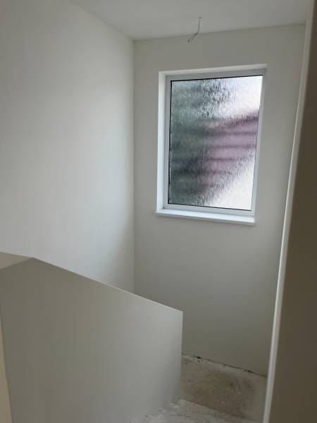 A staircase in a family house with a window with frosted glass.