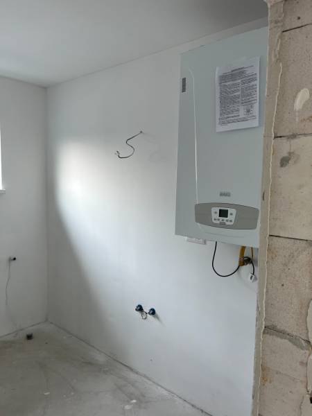 The interior of a family house with a boiler mounted on the wall.