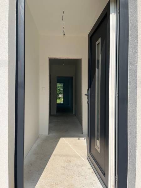 Entrance hall in a family house with a concrete floor and black doors.