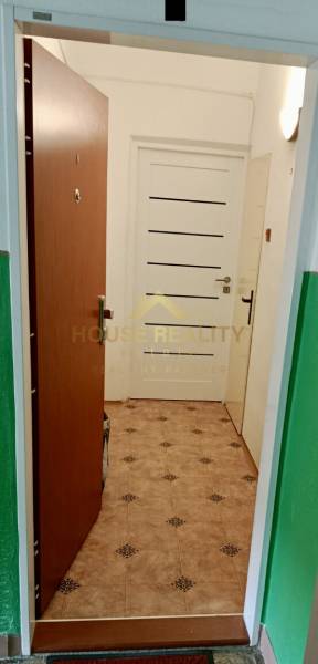 Entrance to the interior with open doors and tiling in a studio apartment.