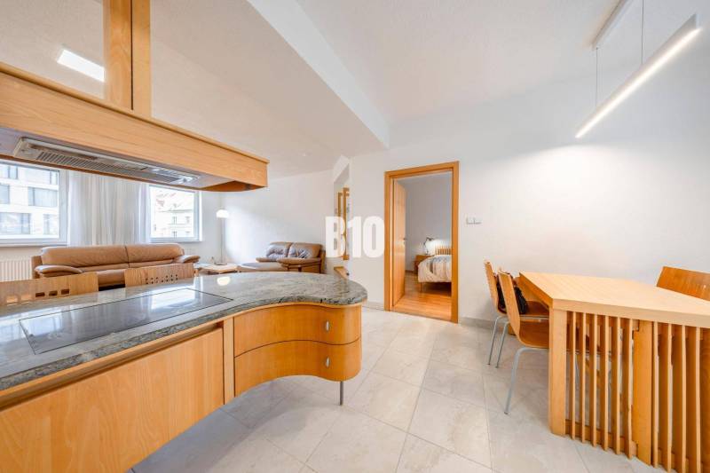 Interior of a 3-room apartment with an open living room, dining table, and cooking area.