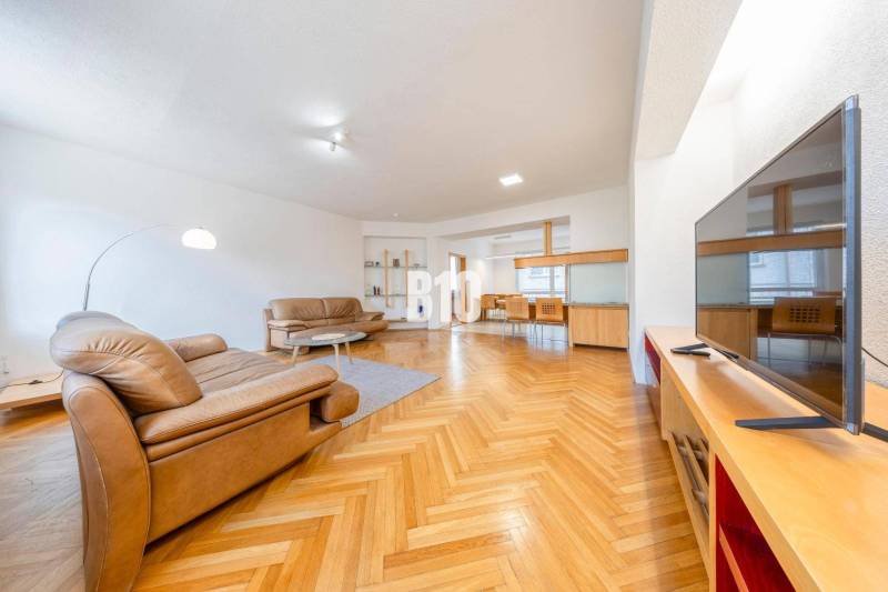 Living room in a 3-room apartment with leather sofas and a floor with a wooden decor.