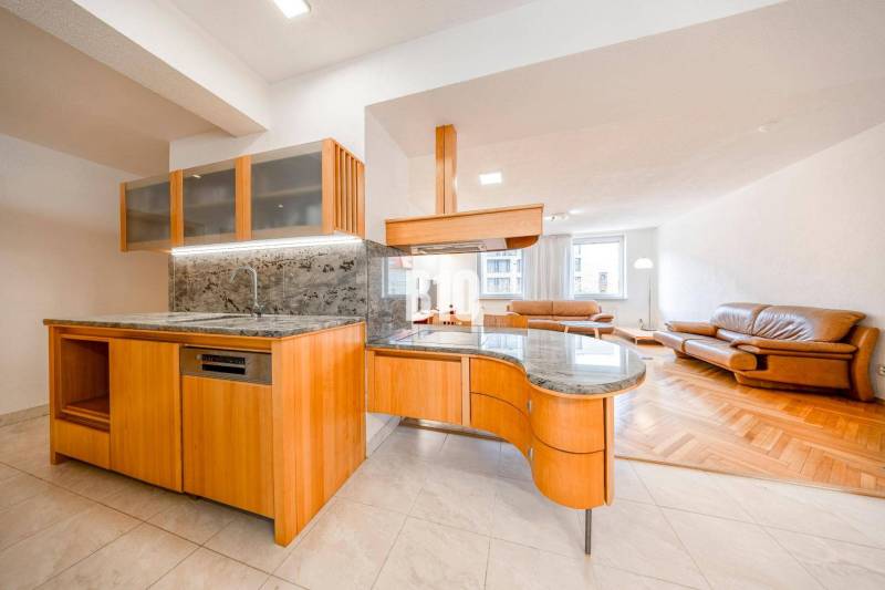 Spacious kitchen with wooden decor and bright living room in a 3-room apartment.