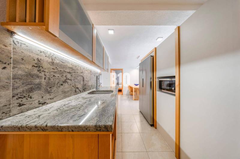 A kitchen in a 3-room apartment with a marble countertop and built-in appliances.