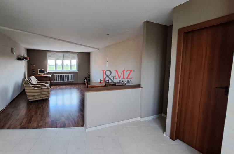 Interior of a family house with a living room, sofa, and computer by the window.