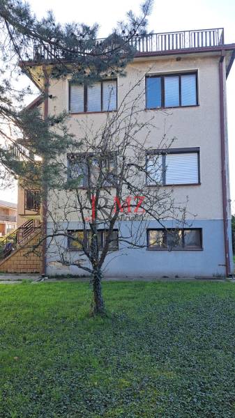A family house in Hronské Kosihy with a garden and a standalone tree.