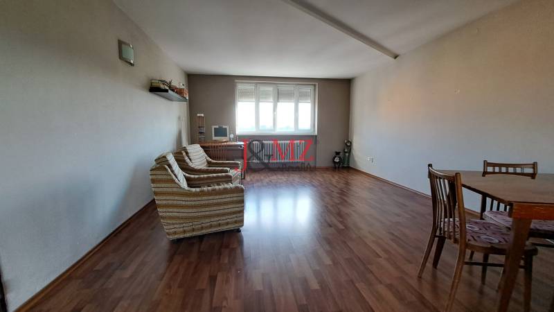 Living room in a family house with wooden flooring, a sofa, and a table.