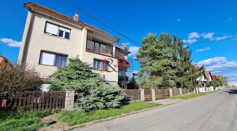 A family house in Hronské Kosihy with two floors, a garden, and a fence on a quiet street.