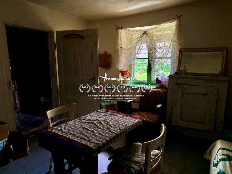 The interior of a family house with antique furniture, floral patterns, and a rustic atmosphere.