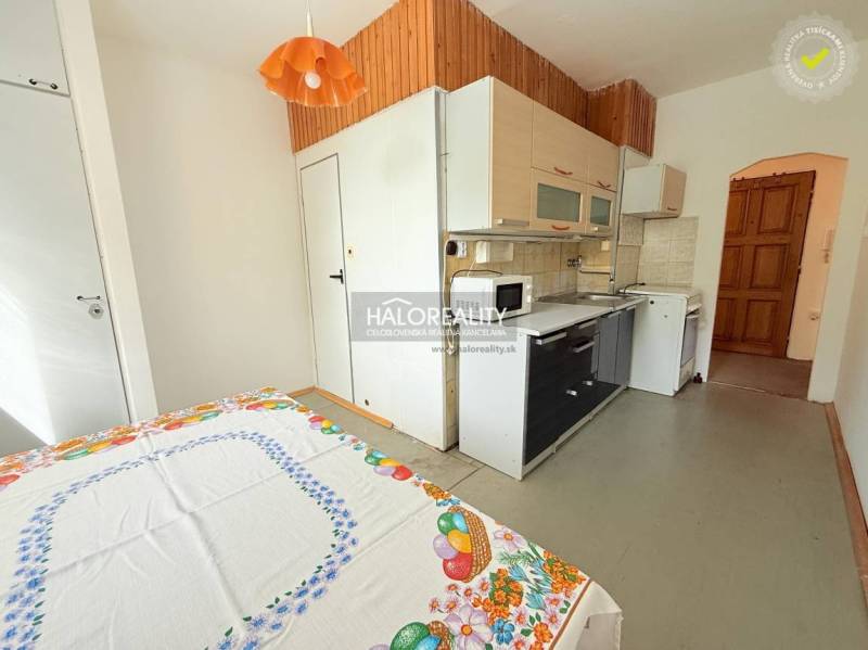 A kitchen in a 2-room apartment with rustic wooden decor and a kitchen unit.