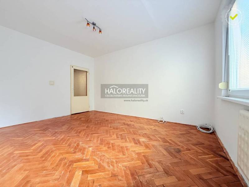 A bright room with a wood-patterned floor in a 2-room apartment.