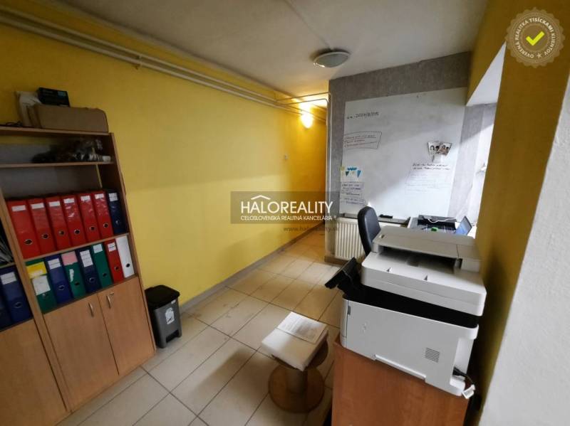 Office space with shelves, binders, yellow walls, and a printer.