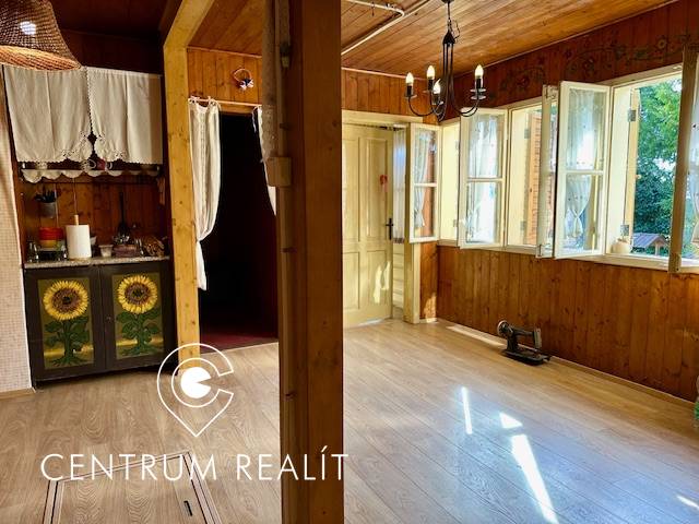 The interior with a wood-patterned floor is dominated by rustic furniture and bright lighting.