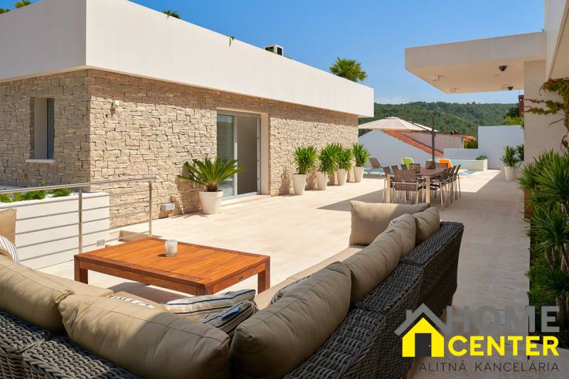 The terrace of the villa in the town of Bol offers comfortable seating and a view of the surroundings.