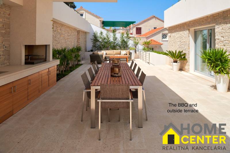 A villa in the town of Bol with an outdoor terrace, table, and grill surrounded by plants.