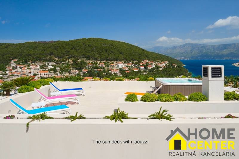 A villa in the town of Bol with a terrace, sunbeds, and a jacuzzi overlooking the surrounding houses and the sea.