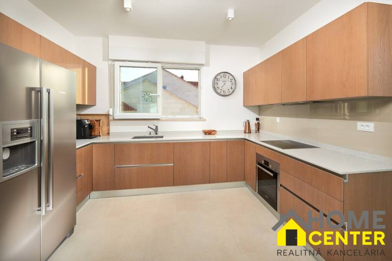 A kitchen in a villa with a wooden decor floor and modern appliances.