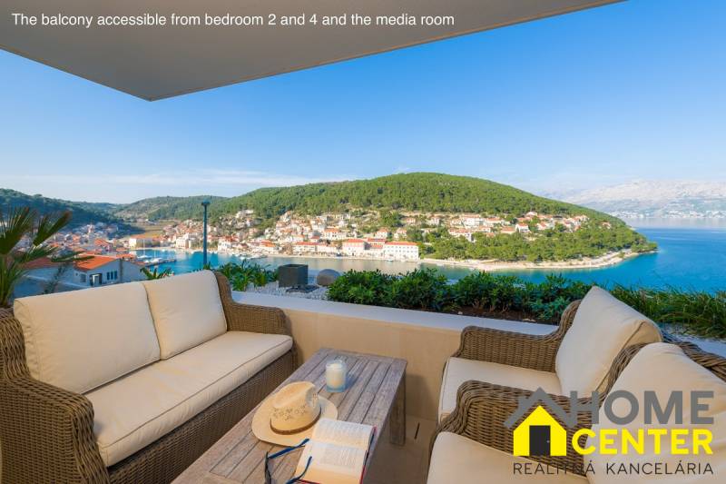 A balcony in a villa in the town of Bol with a view of the bay and greenery.