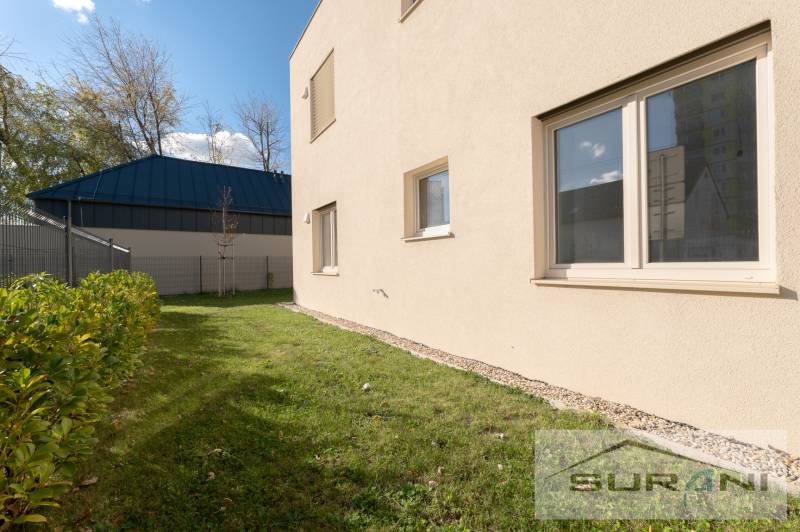 The exterior of a new 2-room apartment on Železničná Street in Bratislava - Vrakuňa, with a landscaped garden.