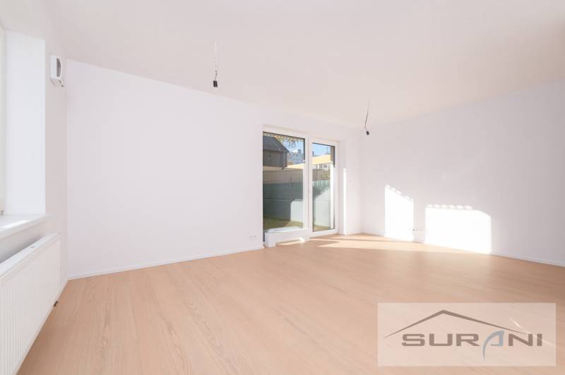 A bright living room with wood-patterned flooring and a large window in a two-room apartment.