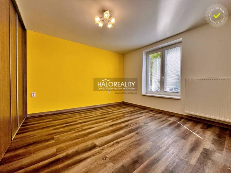 Interior of a 3-room apartment with a yellow wall and a floor with a wooden decor.