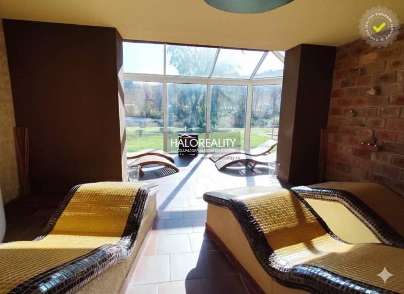 Relaxation zone with heated loungers and glass wall in the gastro area.
