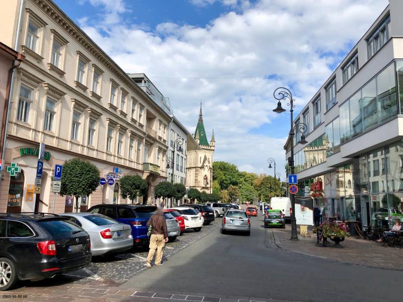 Mlynská Street in the Staré Mesto district, Košice; cars and pedestrians in front of buildings.